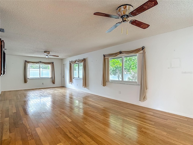 1607 New Bedford Dr, Sun City Center, FL 33573 - spare room featuring a ceiling fan, a textured ceiling, and light wood finished floors