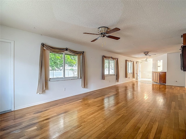 1607 New Bedford Dr, Sun City Center, FL 33573 - unfurnished living room with ceiling fan, a textured ceiling, and wood-type flooring