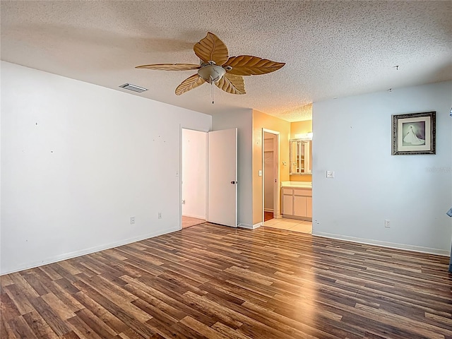 1607 New Bedford Dr, Sun City Center, FL 33573 - unfurnished bedroom with wood finished floors, a textured ceiling, ensuite bath, and ceiling fan