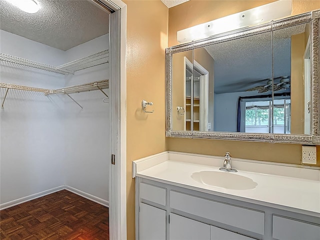 1607 New Bedford Dr, Sun City Center, FL 33573 - bathroom featuring vanity, a walk in closet, and a textured ceiling