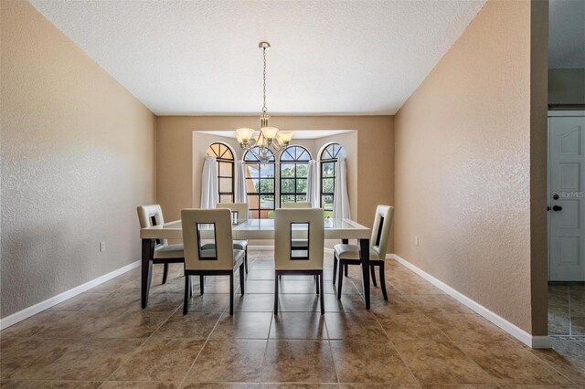 13167 Roseanna Dr, Spring Hill, FL 34609 - tiled dining area featuring a textured wall, a chandelier, and a textured ceiling