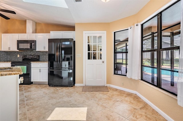13167 Roseanna Dr, Spring Hill, FL 34609 - kitchen featuring black appliances, vaulted ceiling, white cabinetry, and healthy amount of natural light