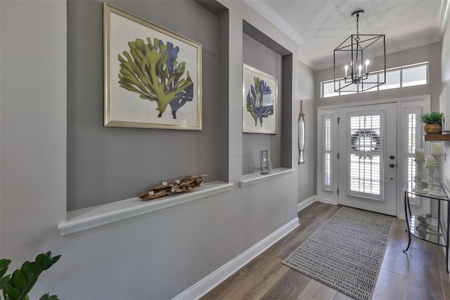5710 Tortoise Pl, Apollo Beach, FL 33572 - foyer entrance featuring a chandelier, ornamental molding, wood finished floors, and a textured ceiling