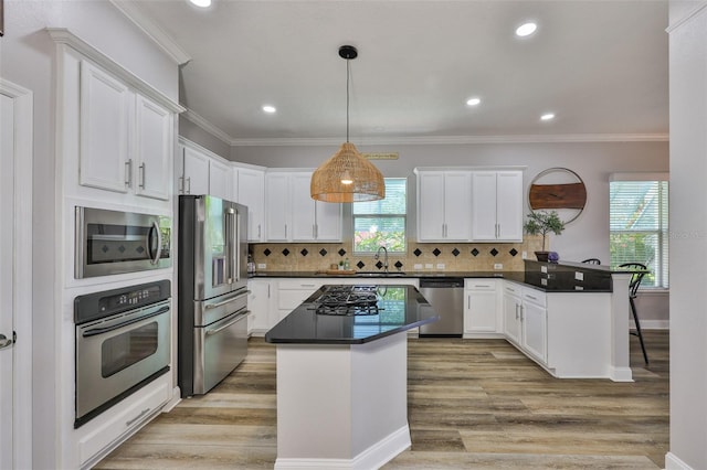 5710 Tortoise Pl, Apollo Beach, FL 33572 - kitchen featuring stainless steel appliances, a peninsula, white cabinets, ornamental molding, and recessed lighting