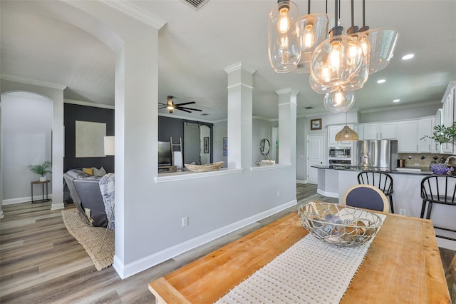 5710 Tortoise Pl, Apollo Beach, FL 33572 - dining space with crown molding, a ceiling fan, light wood-style floors, decorative columns, and recessed lighting