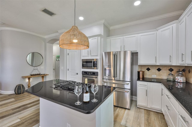 5710 Tortoise Pl, Apollo Beach, FL 33572 - kitchen with stainless steel appliances, white cabinets, light wood-type flooring, arched walkways, and crown molding