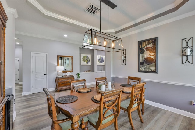 5710 Tortoise Pl, Apollo Beach, FL 33572 - dining room with a tray ceiling, ornamental molding, wood finished floors, a chandelier, and recessed lighting