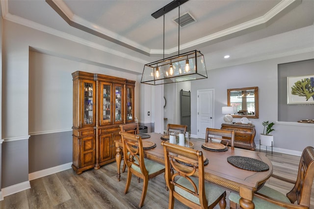 5710 Tortoise Pl, Apollo Beach, FL 33572 - dining space with a tray ceiling, dark wood-style flooring, ornamental molding, and recessed lighting