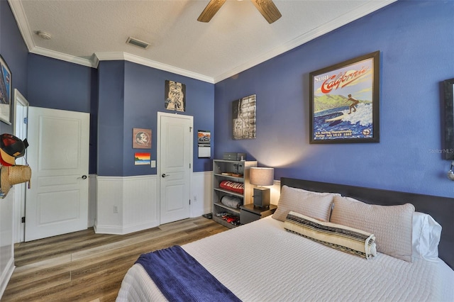 5710 Tortoise Pl, Apollo Beach, FL 33572 - bedroom with wood finished floors, crown molding, ceiling fan, a textured ceiling, and wainscoting