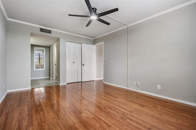 2901 W 26th St Unit 301, Bradenton, FL 34205 - unfurnished bedroom with a textured ceiling, wood finished floors, a closet, a ceiling fan, and ornamental molding