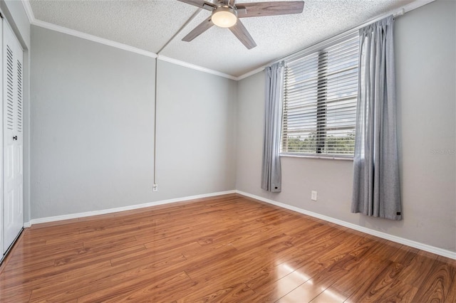 2901 W 26th St Unit 301, Bradenton, FL 34205 - unfurnished bedroom with a textured ceiling, wood finished floors, a closet, crown molding, and ceiling fan