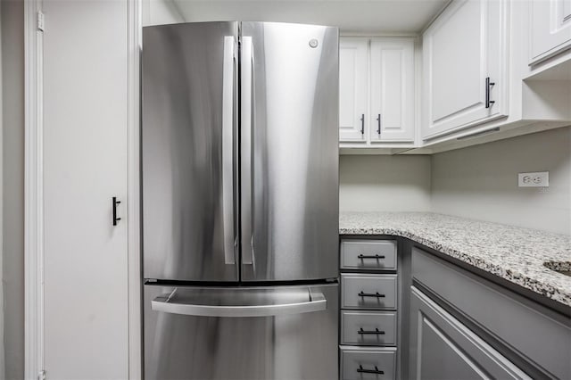 2901 W 26th St Unit 301, Bradenton, FL 34205 - kitchen with freestanding refrigerator, light stone counters, white cabinets, and gray cabinets