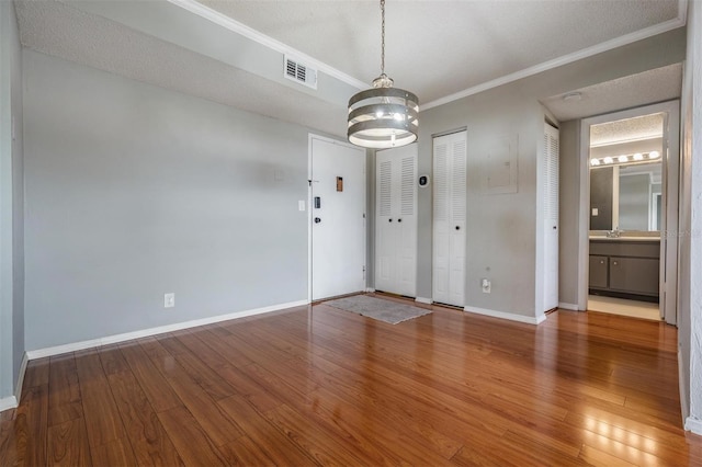 2901 W 26th St Unit 301, Bradenton, FL 34205 - unfurnished room with crown molding, a chandelier, and wood finished floors