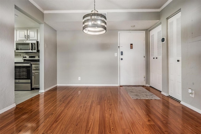 2901 W 26th St Unit 301, Bradenton, FL 34205 - unfurnished dining area with wood finished floors, a chandelier, and crown molding