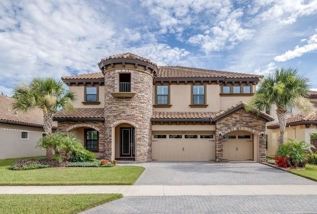 21675 Amelia Rose Way, Land O Lakes, FL 34637 - mediterranean / spanish house with decorative driveway, stucco siding, a tiled roof, and an attached garage