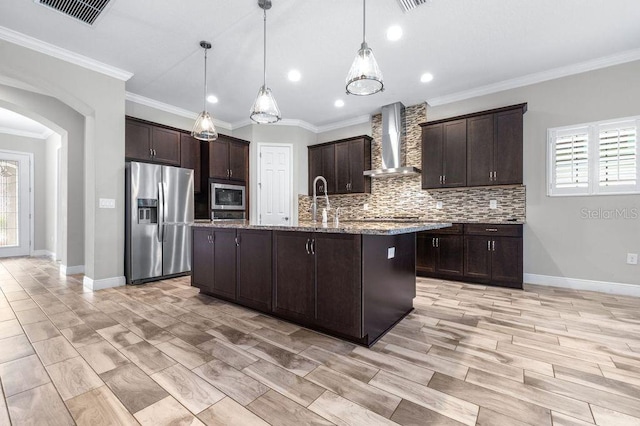 21675 Amelia Rose Way, Land O Lakes, FL 34637 - kitchen featuring stainless steel appliances, wall chimney range hood, arched walkways, healthy amount of natural light, and crown molding