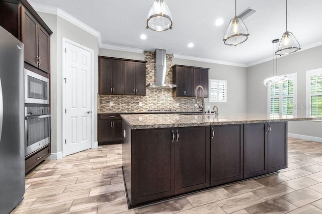 21675 Amelia Rose Way, Land O Lakes, FL 34637 - kitchen featuring stainless steel appliances, wall chimney exhaust hood, crown molding, dark brown cabinets, and light stone counters