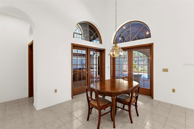 3772 Woodridge Pl, Palm Harbor, FL 34684 - dining room featuring french doors, plenty of natural light, a high ceiling, arched walkways, and light tile patterned floors