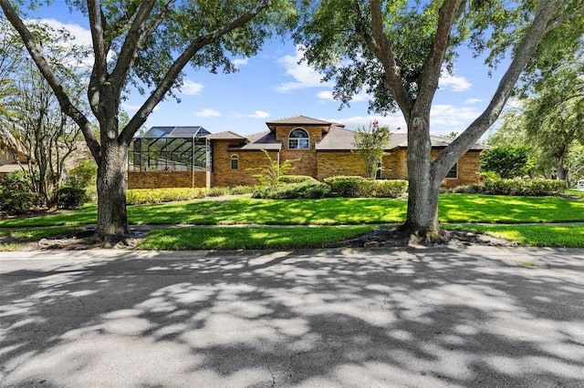 3772 Woodridge Pl, Palm Harbor, FL 34684 - view of front of property featuring a front lawn, brick siding, and glass enclosure