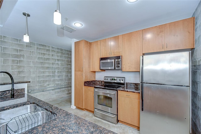 2001 E 2nd Ave Unit 12, Tampa, FL 33605 - kitchen with appliances with stainless steel finishes, concrete floors, dark stone countertops, hanging light fixtures, and concrete block wall