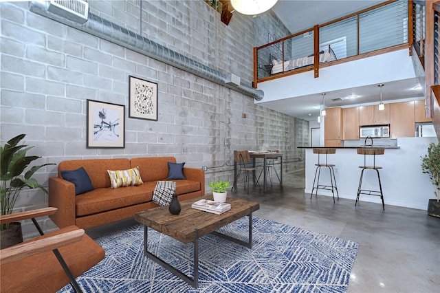 2001 E 2nd Ave Unit 12, Tampa, FL 33605 - living area featuring finished concrete floors, a towering ceiling, and concrete block wall