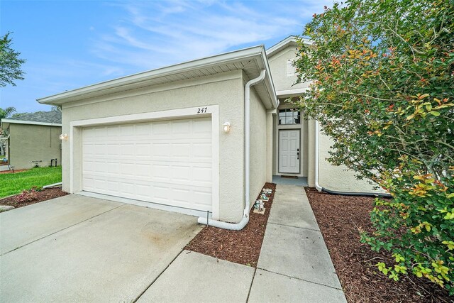 247 Winthrop Dr, Spring Hill, FL 34609 - view of front of home featuring stucco siding, concrete driveway, and an attached garage