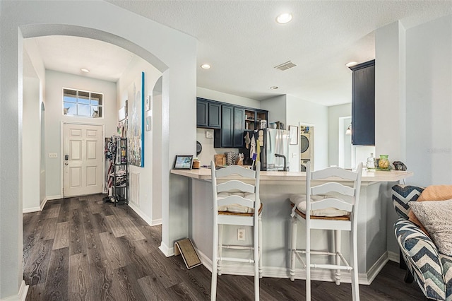 247 Winthrop Dr, Spring Hill, FL 34609 - kitchen featuring freestanding refrigerator, dark wood-style flooring, arched walkways, a breakfast bar area, and recessed lighting