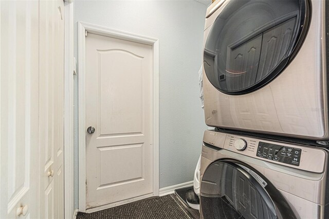 247 Winthrop Dr, Spring Hill, FL 34609 - washroom with stacked washing machine and dryer and dark tile patterned floors