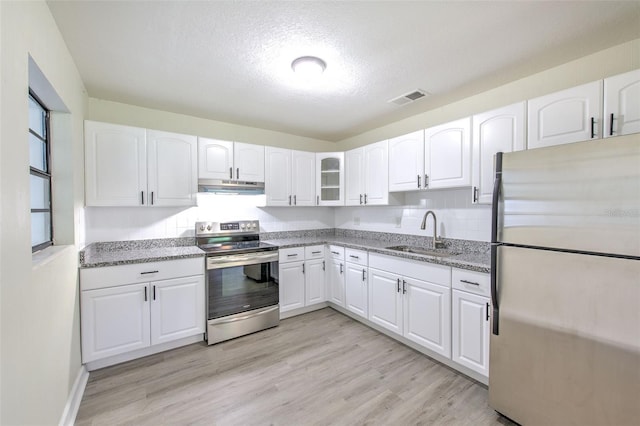 475 W Ethelene St, Bartow, FL 33830 - kitchen featuring stainless steel appliances, under cabinet range hood, light stone counters, white cabinetry, and a textured ceiling