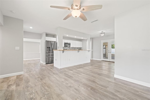 6012 Flora Ter, Apollo Beach, FL 33572 - unfurnished living room featuring a ceiling fan, light wood finished floors, recessed lighting, and french doors