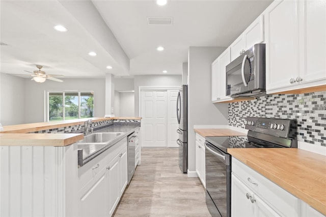 6012 Flora Ter, Apollo Beach, FL 33572 - kitchen featuring stainless steel appliances, recessed lighting, white cabinets, tasteful backsplash, and light wood-style flooring