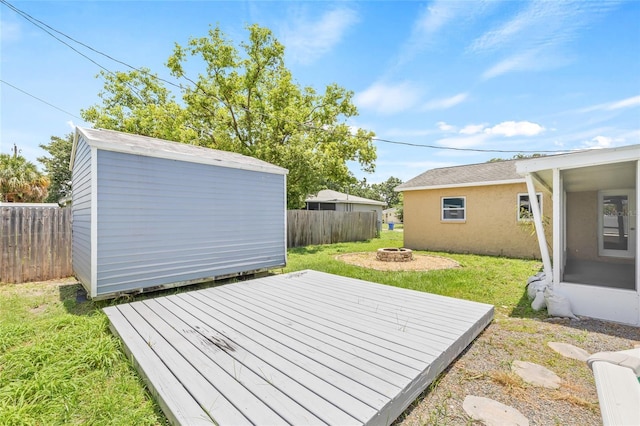 6012 Flora Ter, Apollo Beach, FL 33572 - fenced backyard featuring an outdoor fire pit, a wooden deck, and a shed