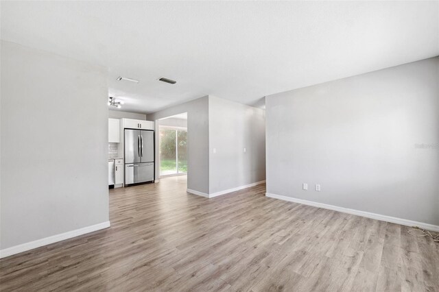 7891 67th St N, Pinellas Park, FL 33781 - unfurnished living room featuring light wood finished floors and baseboards