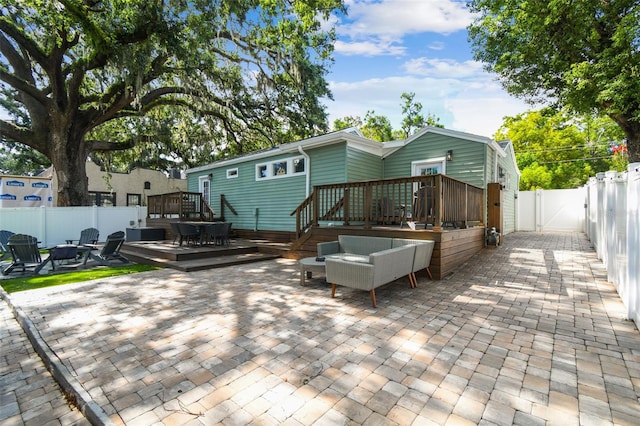 1208 E Crenshaw St, Tampa, FL 33604 - rear view of property with a wooden deck, an outdoor fire pit, a fenced backyard, a patio area, and a gate