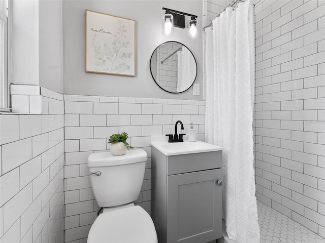 5514 7th Ave N, Saint Petersburg, FL 33710 - bathroom featuring tile walls, vanity, a tile shower, and a wainscoted wall
