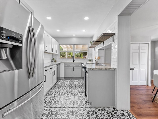 5514 7th Ave N, Saint Petersburg, FL 33710 - kitchen featuring appliances with stainless steel finishes, backsplash, light stone countertops, open shelves, and recessed lighting