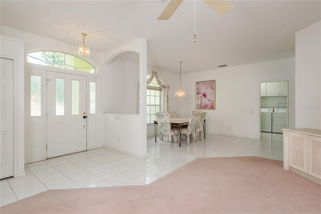 1156 Ridgegrove Dr W, Palm Harbor, FL 34683 - entrance foyer featuring washing machine and clothes dryer, light tile patterned flooring, light carpet, and a chandelier