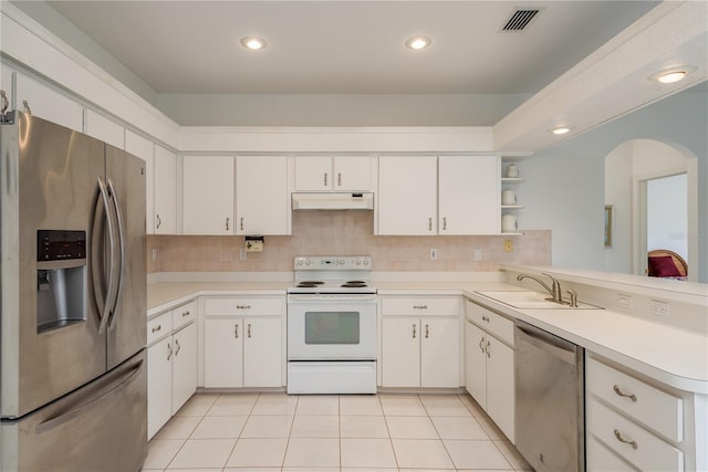 1156 Ridgegrove Dr W, Palm Harbor, FL 34683 - kitchen with stainless steel appliances, under cabinet range hood, arched walkways, light countertops, and recessed lighting