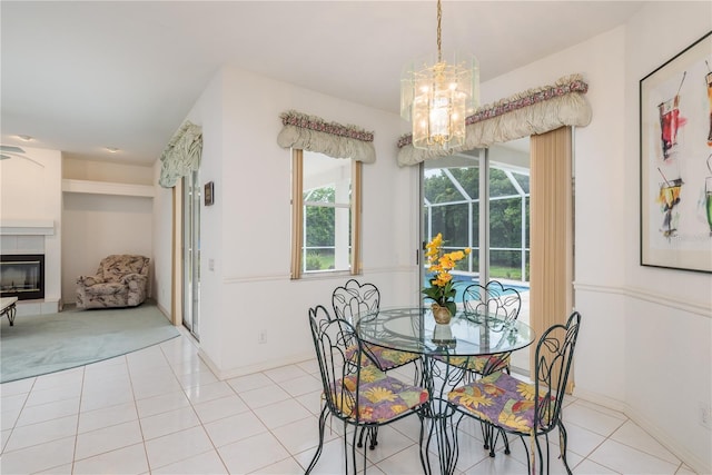1156 Ridgegrove Dr W, Palm Harbor, FL 34683 - dining space with a chandelier, light tile patterned floors, and a fireplace