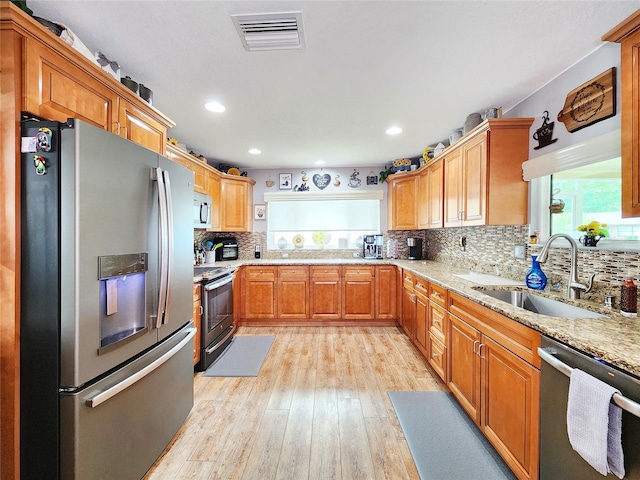 8110 Damara Dr, New Port Richey, FL 34653 - kitchen featuring stainless steel appliances, light stone counters, tasteful backsplash, recessed lighting, and light wood-type flooring