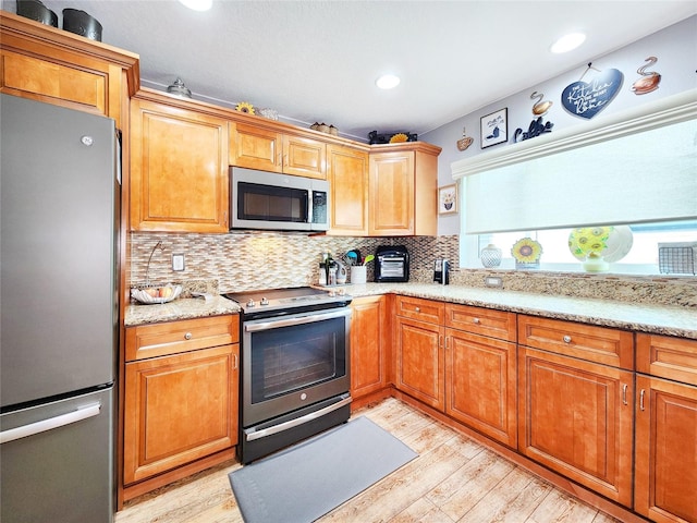 8110 Damara Dr, New Port Richey, FL 34653 - kitchen with stainless steel appliances, light wood-style flooring, decorative backsplash, light stone countertops, and recessed lighting