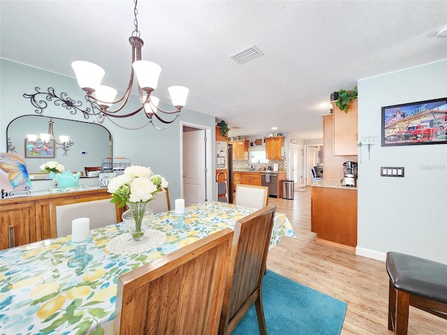 8110 Damara Dr, New Port Richey, FL 34653 - dining space featuring a chandelier and light wood-type flooring
