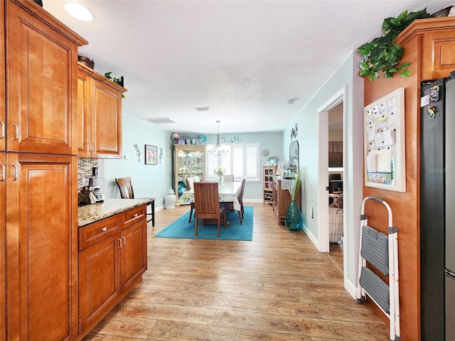 8110 Damara Dr, New Port Richey, FL 34653 - dining area with a chandelier, light wood finished floors, and heating unit