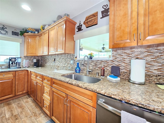 8110 Damara Dr, New Port Richey, FL 34653 - kitchen with stainless steel dishwasher, light stone counters, backsplash, and light wood-style floors