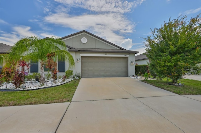 4485 Eternal Prince Dr, Sun City Center, FL 33573 - view of front of home featuring driveway, a garage, stucco siding, and a front yard