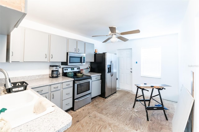 120371/2 Murray Ave, Seminole, FL 33778 - kitchen featuring stainless steel appliances, ceiling fan, light countertops, and light wood finished floors