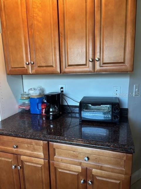 1021 16th Ave SW, Largo, FL 33770 - kitchen featuring brown cabinetry and dark stone countertops