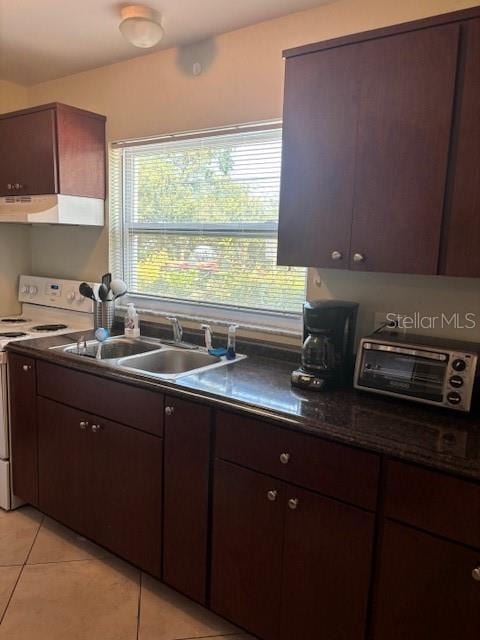 1021 16th Ave SW, Largo, FL 33770 - kitchen with electric range, extractor fan, dark countertops, light tile patterned floors, and dark brown cabinets
