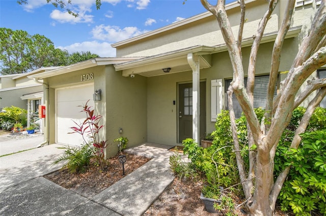 1508 Adams Cir E, Largo, FL 33771 - doorway to property featuring an attached garage, stucco siding, and driveway