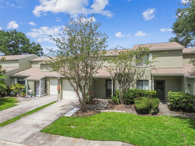 1508 Adams Cir E, Largo, FL 33771 - view of front of house featuring an attached garage, stucco siding, driveway, a front lawn, and a shingled roof